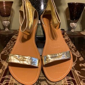 Gently loved Gold women sandals with strap in the front and zipper back size 10.
